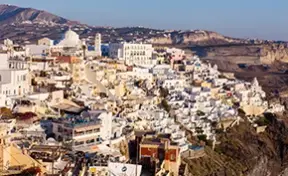 Postales inolvidables de casas blancas y cúpulas azules en Thira.